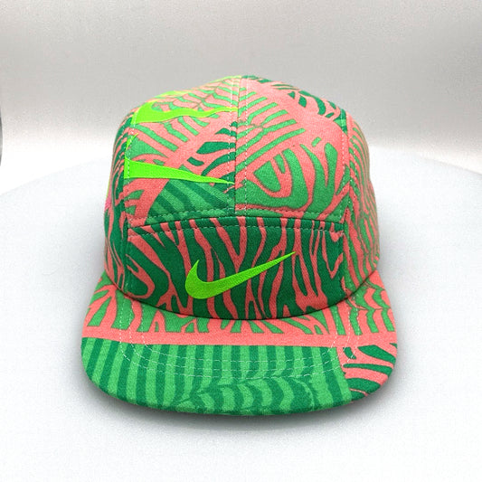 Fluorescent green and pink Nike sweatshirt fleece upcycled into a 5 Panel Hat, Nike logos throughout, with a white background.