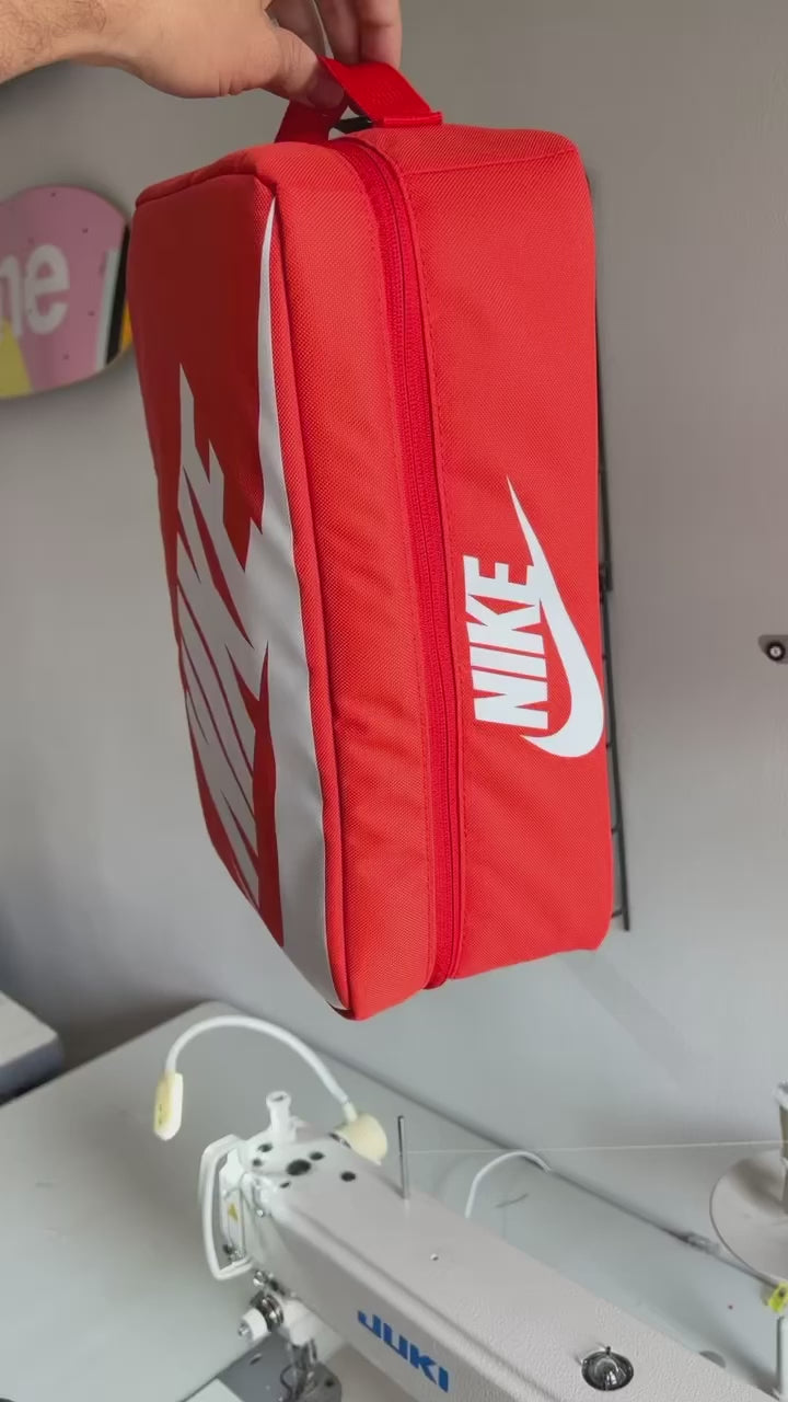 The making of a orange and white NIKE shoe box bag upcycled to a 5 Panel Hat, zipper on right side panel, with white background.