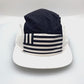 Spinning navy and white North Face 5 Panel Hat, flag print on the front, with a white background.