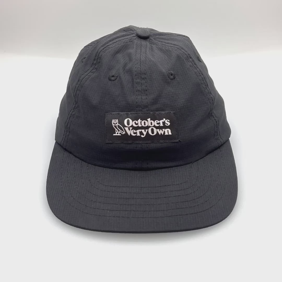 Spinning black OVO 6 Panel Hat, October's Very Own logo on the front, with a white background.
