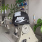 The making of a Black and white NIKE shoe box bag upcycled to a 5 Panel Hat, zipper on right side panel, with white background.