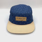 Spinning tan and navy polka dots TWLOHA 5 Panel Hat, leather logo on the front, with a white background.